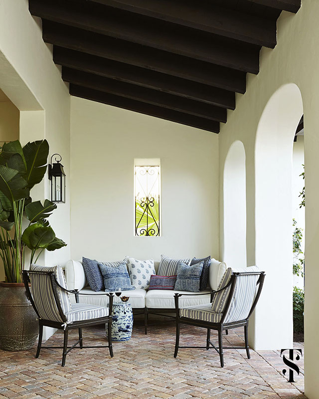 Naples Interior Design Architecture | interior designer & interior architecture by Summer Thornton | outdoor lounge seating in blue and white on a brick patio with curved arches and wood beams - www.summerthorntondesign.com
