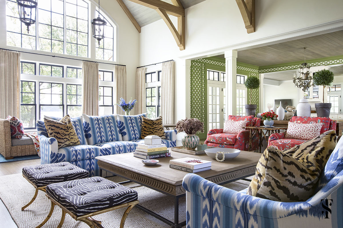 wisconsin lake house interior design by summer thornton with blue ikat sofa in Brunschwig & Fils Chenonceaux, vaulted ceiling with exposed beams and green trellis in background. www.summerthorntondesign.com