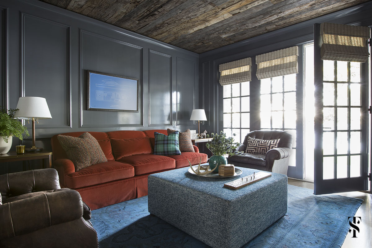 high gloss den with orange sofa, blue overdye rug and wood ceiling; interior design by summer thornton www.summerthorntondesign.com