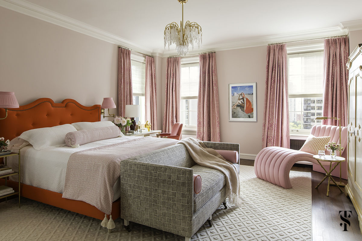 Pink and red bedroom with tufted red headboard, pink walls, brass sconces, and vintage chandelier. Interior design by Summer Thornton Design in Chicago.