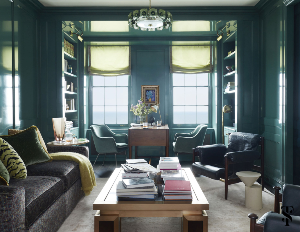 Den and home office designed by Summer Thornton featuring built-in bookshelves and a sleeper-sofa by CAI designs upholstered in Creation Metaphores Giverny Jungle fabric. Lounge chairs in foreground are vintage Erik Merthen's Ire chairs from 1964 in rosewood. Walls are Fine Paints of Europe lacquer in a custom color. The chandelier is vintage Orrefors.