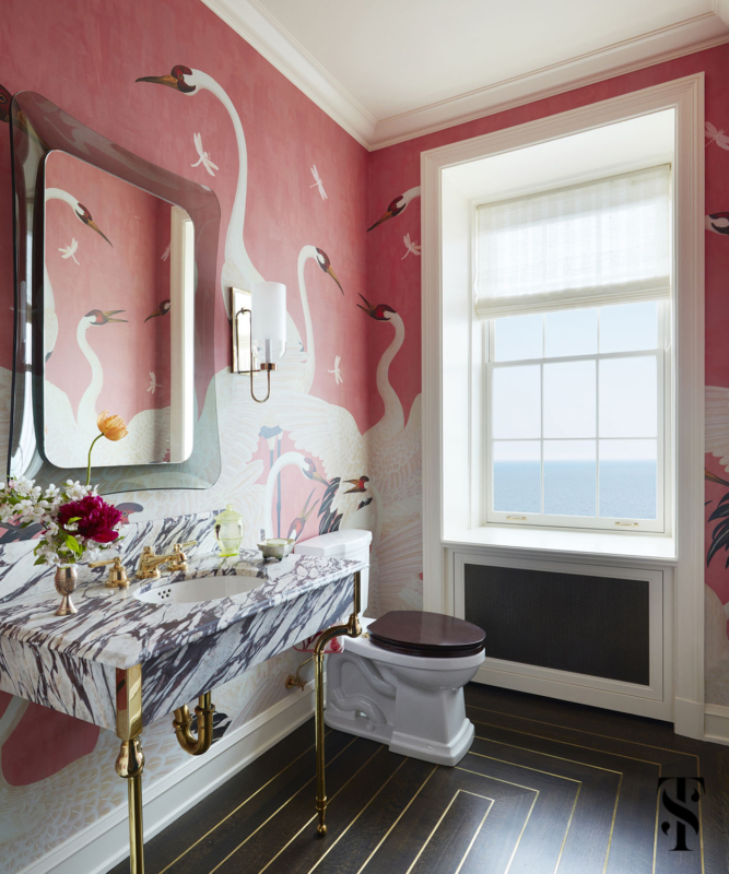 Summer Thornton designed this over-the-top powder room featuring pink herron birds by Gucci and flooring with brass inlays in concentric rectangles.