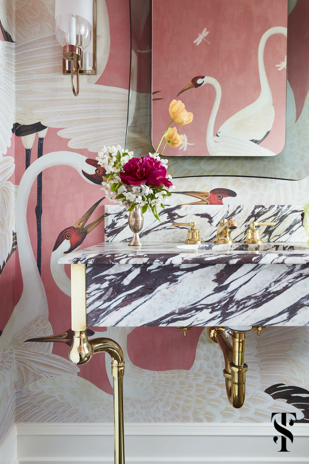 Summer Thornton designed this over-the-top powder room featuring pink herron birds by Gucci and flooring with brass inlays in concentric rectangles.