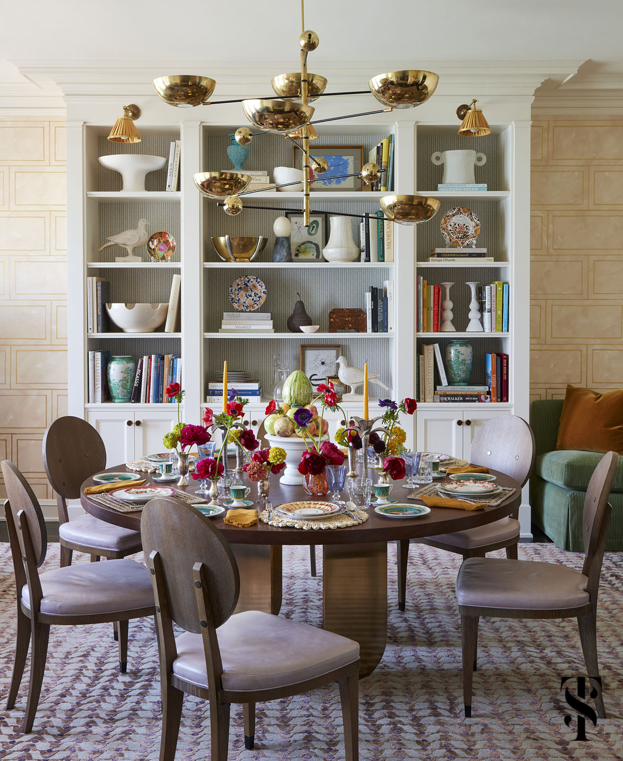 The dining room of a Chicago co-op designed by Summer Thornton featuring a custom designed hand painted wallcovering, custom walnut dining table and vintage brass chandelier.