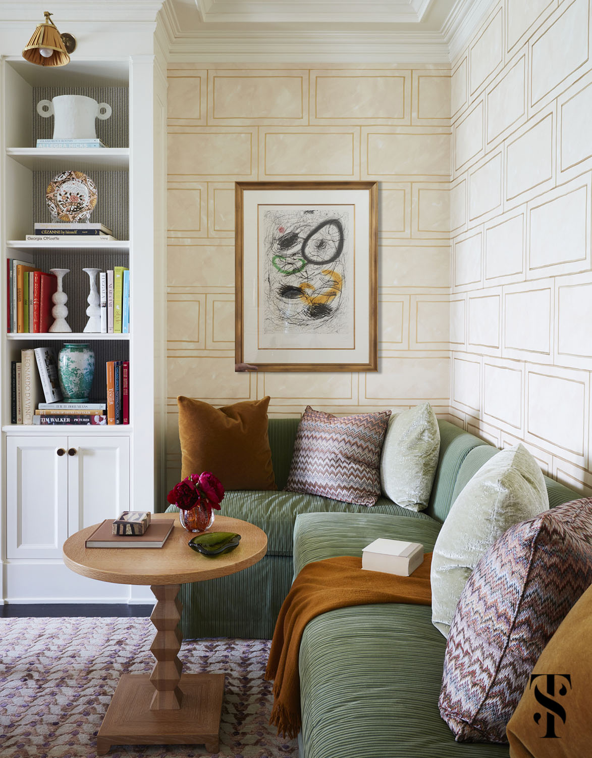 A built-in banquette seating area in the dining room for lounging before or after meals, or for reading a book. Room designed by Summer Thornton and featuring custom designed hand-painted wallpaper and Miro Le Chevelure artwork