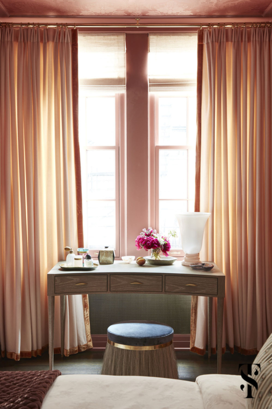 Designed by Summer Thornton, this primary bedroom has a makeup desk, horsehair stool, and de Gournay pineapple demask in raspberry and matching paint.