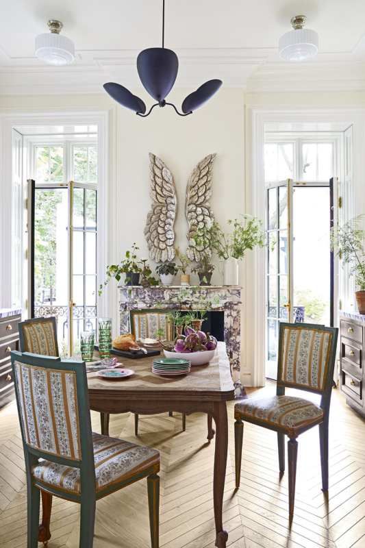 Summer Thornton’s personal Chicago residence designed by Summer Thornton. Kitchen features chevron floors, mahogany cabinetry, a center table and a 17th century marble fireplace with silver leaf gilded wings above.