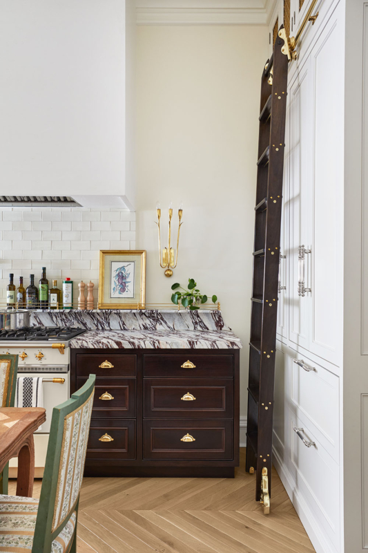 Summer Thornton’s personal Chicago residence designed by Summer Thornton. Kitchen features chevron floors, a plaster hood, mahogany cabinetry and a rolling ladder.