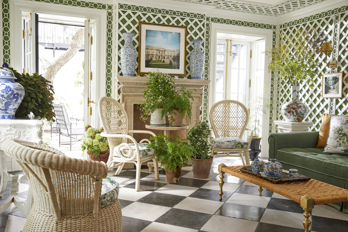 Summer Thornton’s personal Chicago residence designed by Summer Thornton. Garden room features Boxwood green walls clad in lattice work, wicker furniture, New Orleans inspired checkered flooring and French doors and pocket shutters.
