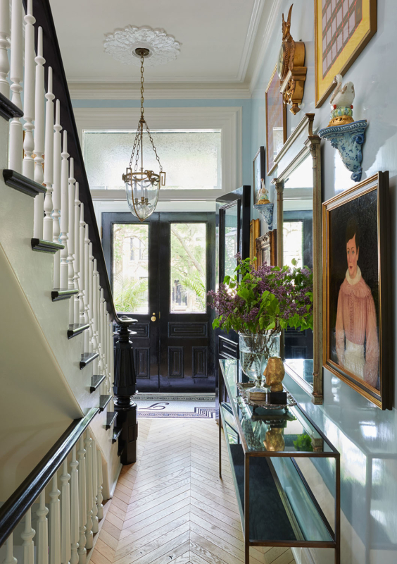 Summer Thornton’s personal Chicago residence designed by Summer Thornton. Foyer features high gloss blue walls, leopard print stair runner, herring bone floors and a gallery wall.